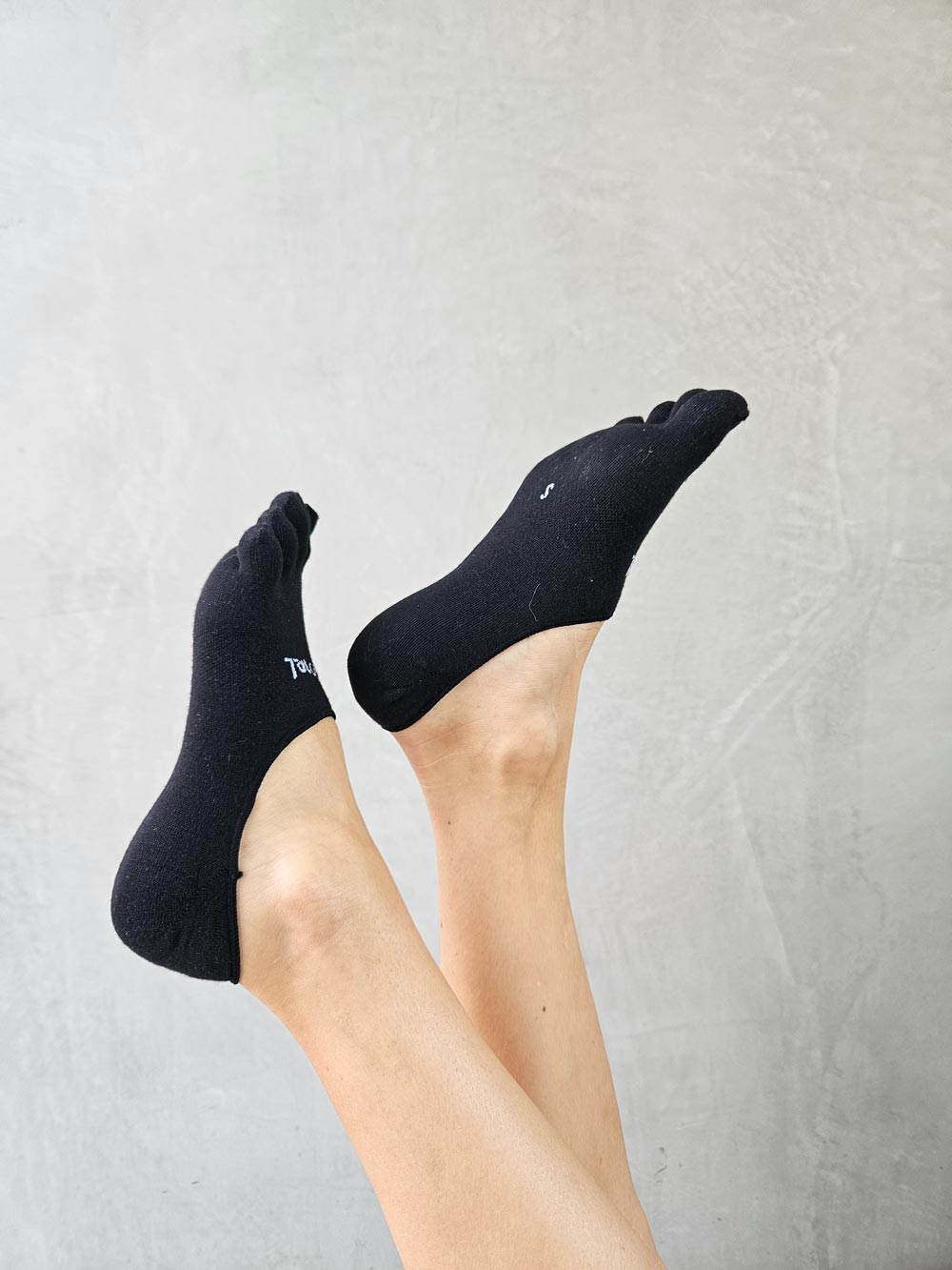 Black Bprimal Everyday Five-Toe Socks - Hidden worn by a person with a light gray background