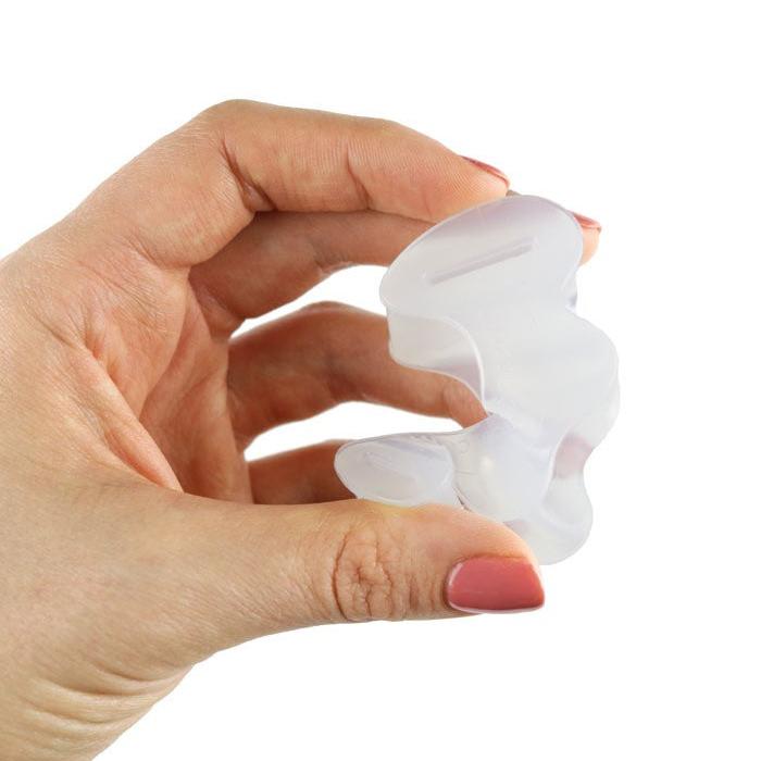 Close up of a hand squeezing a flexible silicone Correct Toes® Toe Spacer