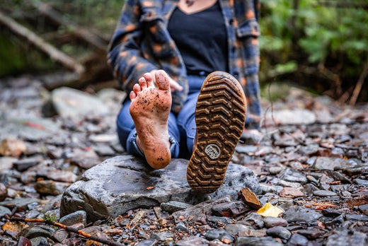 woman showing her barefoot and other foot wearing barefoot shoes