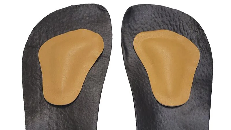 Bprimal metatarsal pads positioned behind the ball of the foot for forefoot pressure relief