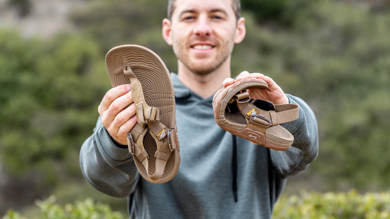 Lems Switchback sandal held in hand, showing flexible sole and adjustable straps for outdoor barefoot comfort