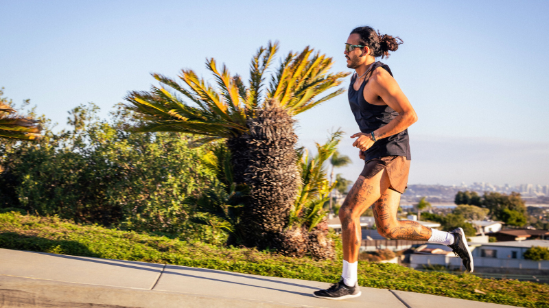 Vivobarefoot Primus Lite Knit Obsidian barefoot running shoes worn by runner on pavement showing natural stride and ground feel