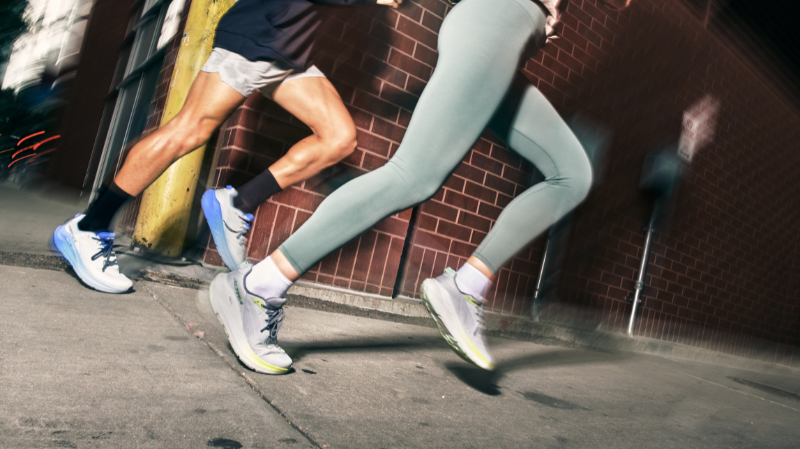 Runners wearing Altra running shoes sprinting on urban pavement at night, highlighting zero drop design and natural stride movement
