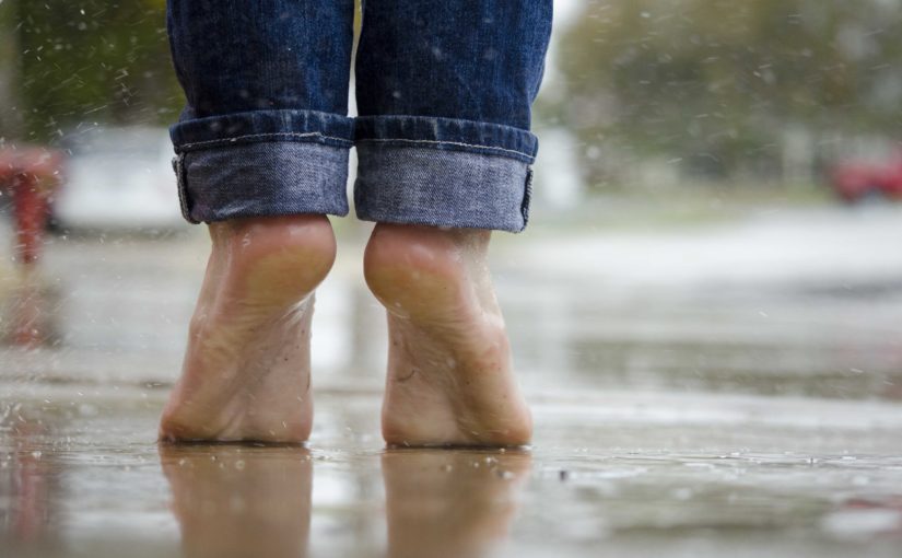 person standing in the rain bare foot