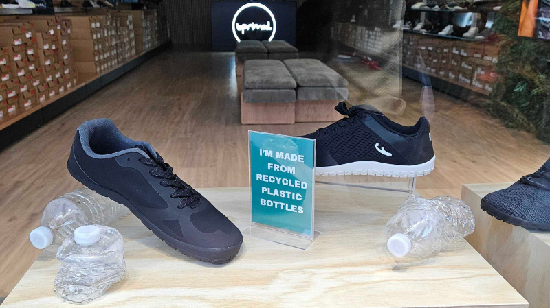 Freet barefoot shoes displayed in store with recycled plastic bottles and sign highlighting eco-friendly materials and sustainable design